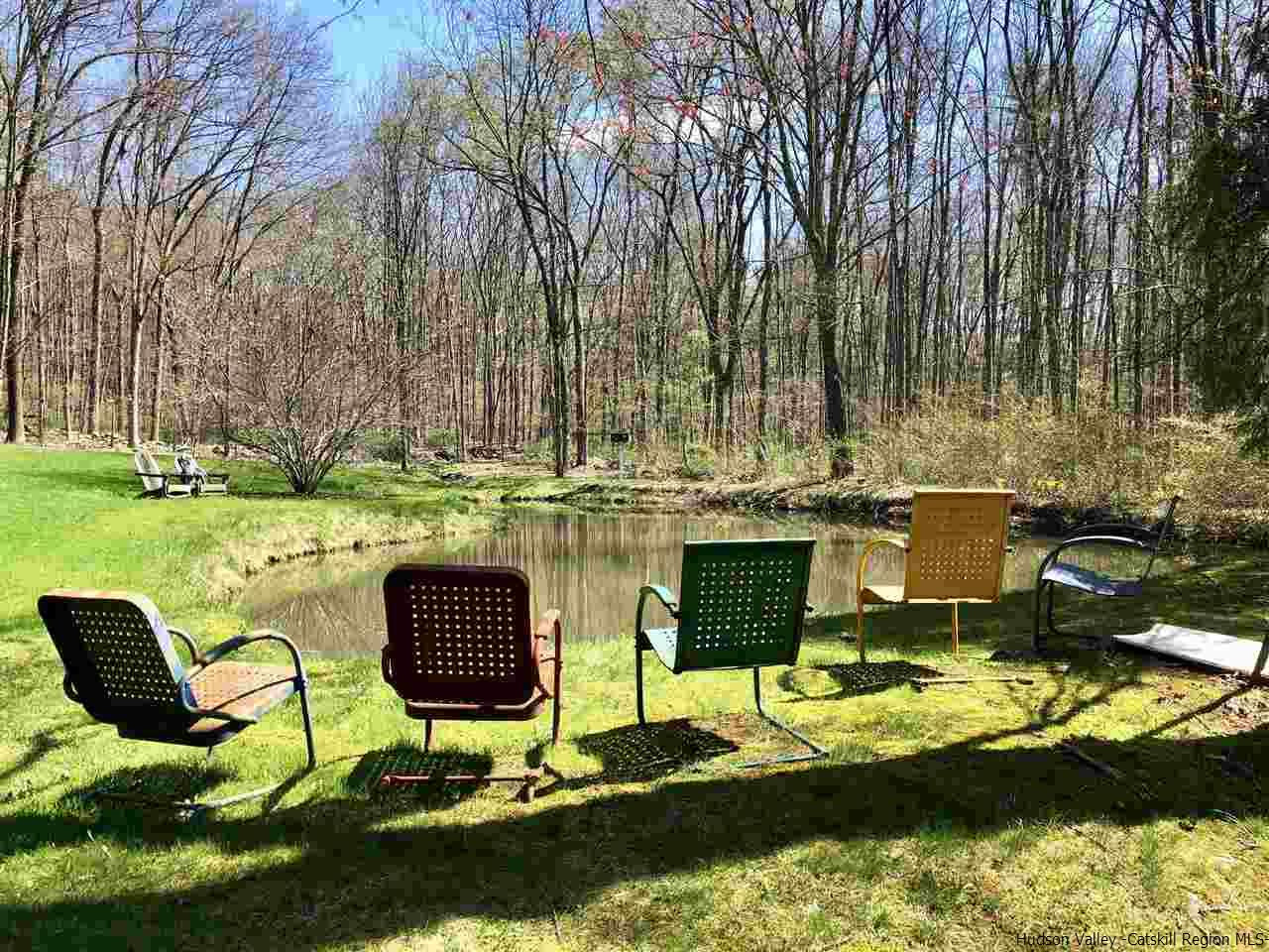 52 Buck Road Stone Ridge, NY 12484 - Photo 3 of 35 a view of a lake with couches chairs and a yard