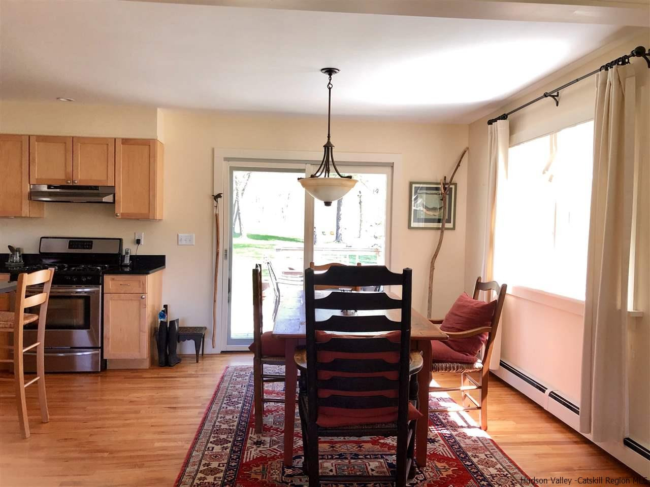 52 Buck Road Stone Ridge, NY 12484 - Photo 9 of 35 a dining room with furniture a chandelier and wooden floor