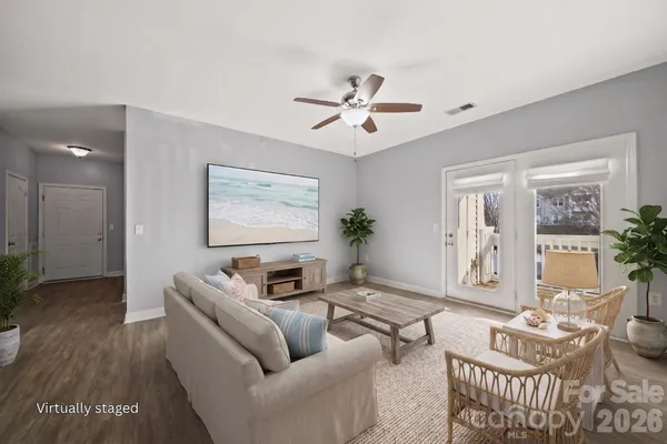 a view of an empty room with chandelier fan and wooden floor