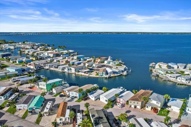 a view of a swimming pool with a lawn chairs and palm trees