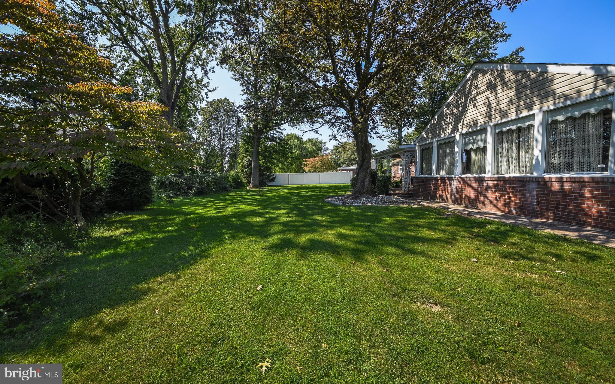 2083 Williamsburg Road Huntingdon Valley, PA 19006 - Photo 32 of 46 a view of a backyard with table and chairs and a large tree