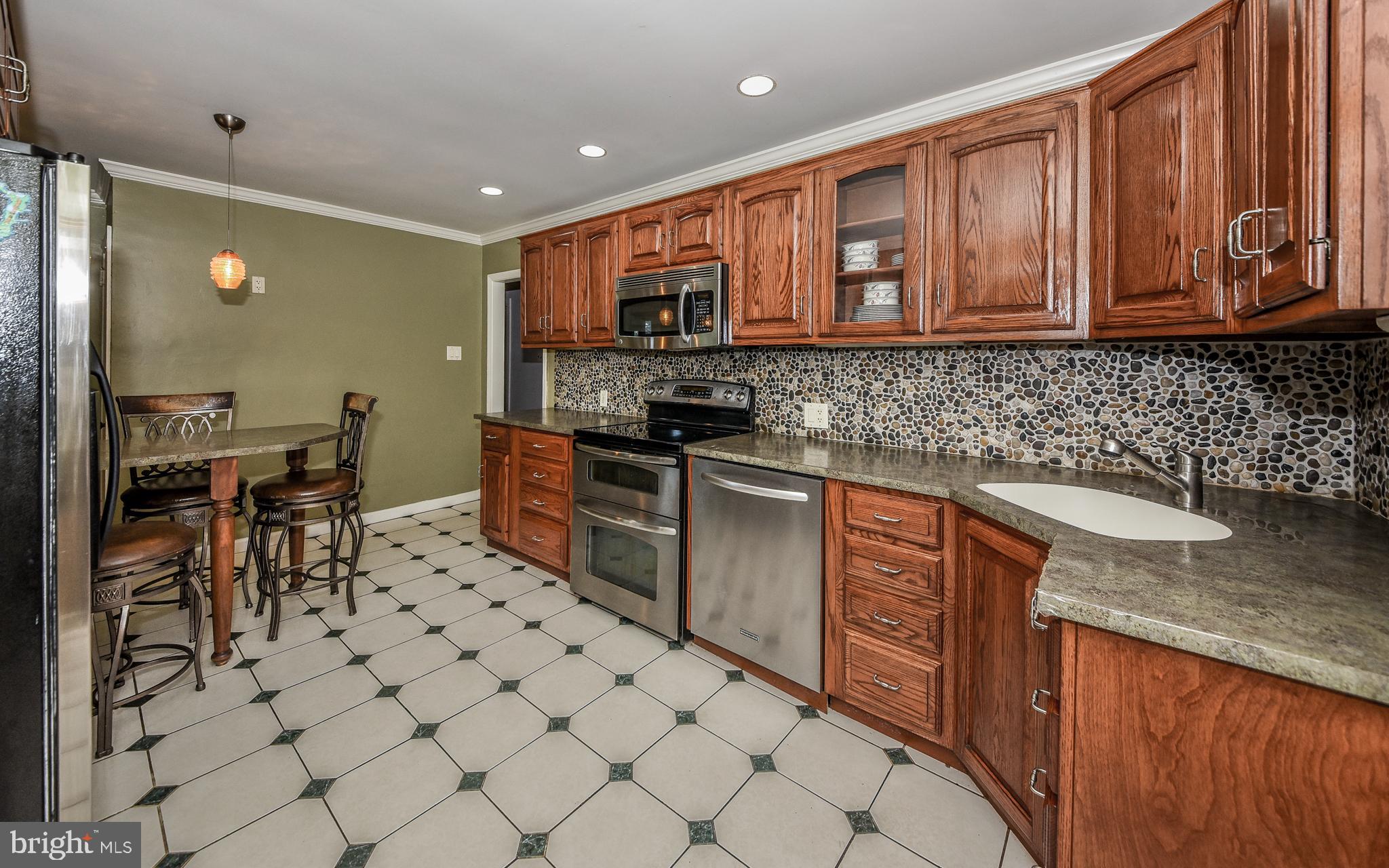2083 Williamsburg Road Huntingdon Valley, PA 19006 - Photo 7 of 46 a kitchen with stainless steel appliances granite countertop a sink stove and cabinets