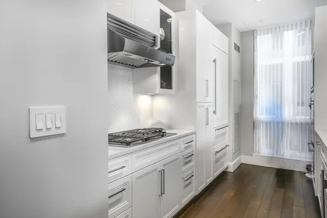 a kitchen with white cabinets and appliances