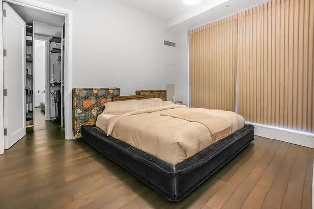 a large bed sitting in a bedroom next to a window