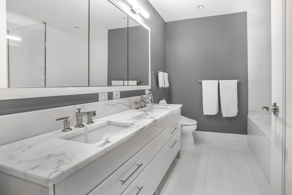 22 Liberty Drive, Unit 7M Boston, MA 02210 - Photo 18 of 31 a bathroom with a sink a toilet and mirror