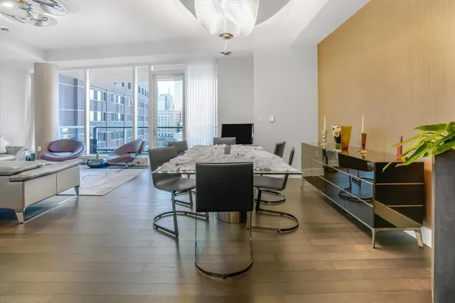 a living room with furniture floor to ceiling window and wooden floor