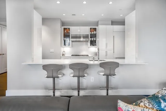 a kitchen with stainless steel appliances kitchen island granite countertop a sink and a cabinets