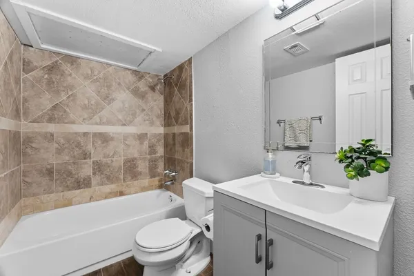 a bathroom with a sink mirror toilet and bathtub