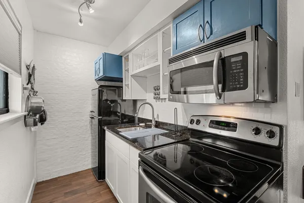 a kitchen with stainless steel appliances granite countertop a stove and a microwave