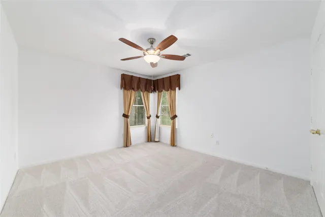 a view of a big room with wooden floor and a ceiling fan