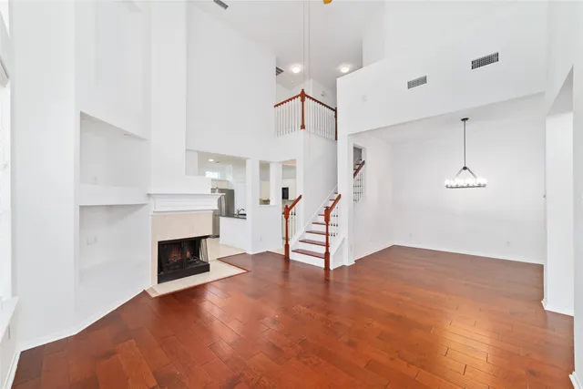 a view of empty room with wooden floor and fireplace