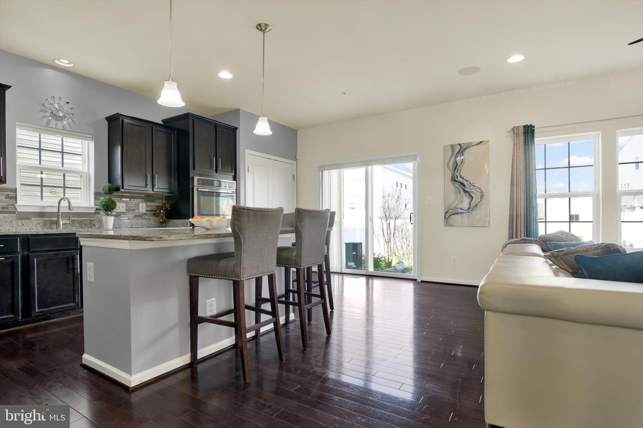 637 Bentgrass Drive Aberdeen, MD 21001 - Photo 8 of 35 a kitchen with stainless steel appliances granite countertop a stove a sink dishwasher a microwave oven and a dining table with wooden floor