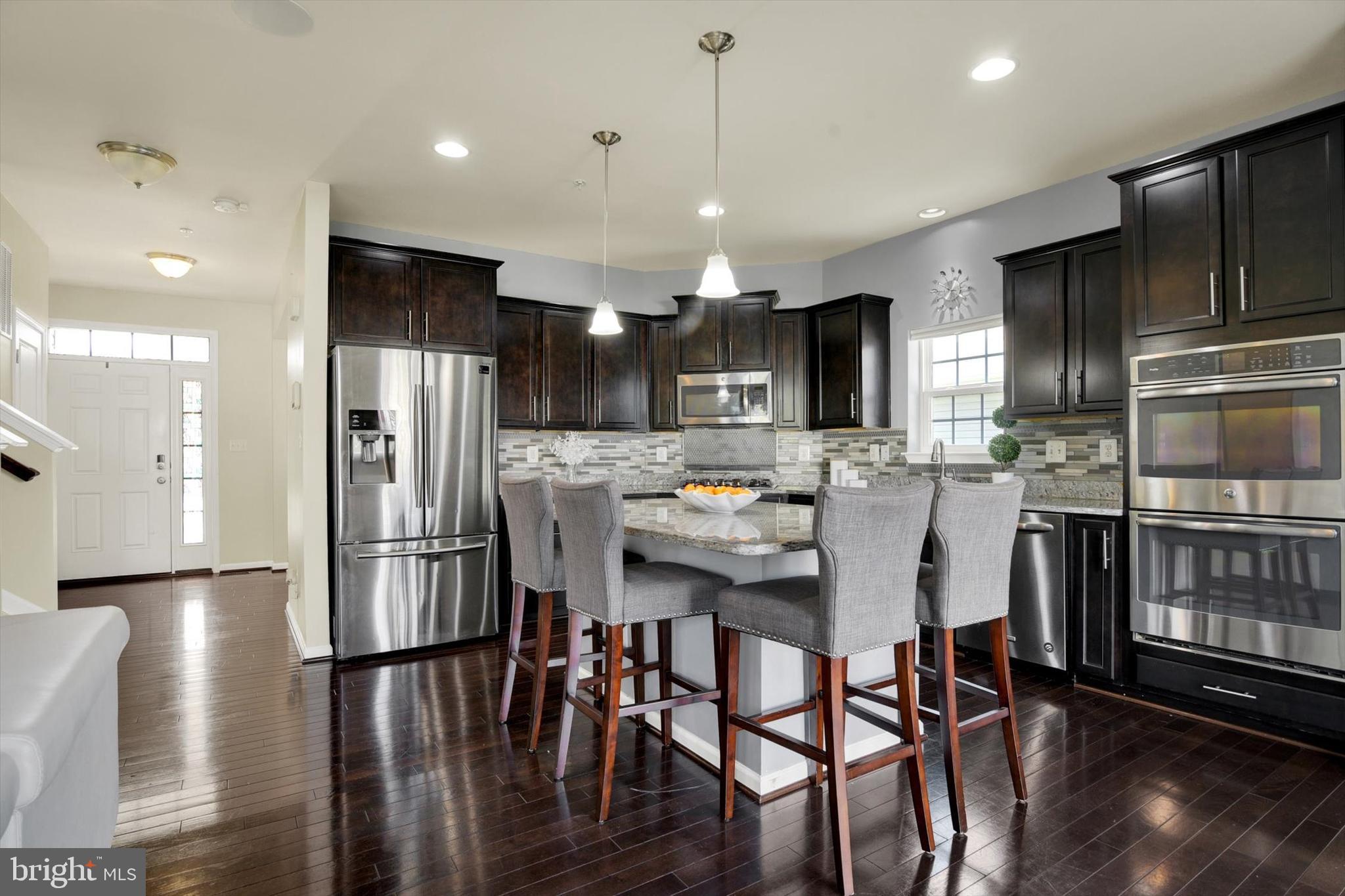 637 Bentgrass Drive Aberdeen, MD 21001 - Photo 9 of 35 a kitchen with stainless steel appliances a dining table chairs refrigerator and cabinets