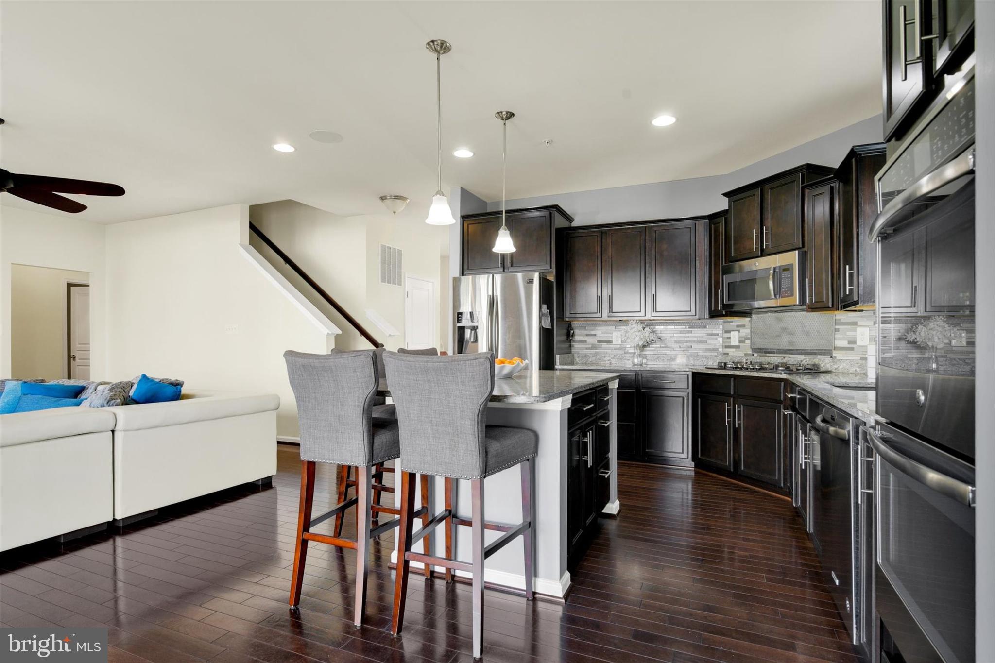 637 Bentgrass Drive Aberdeen, MD 21001 - Photo 10 of 35 a kitchen with stainless steel appliances kitchen island granite countertop a table chairs and a refrigerator