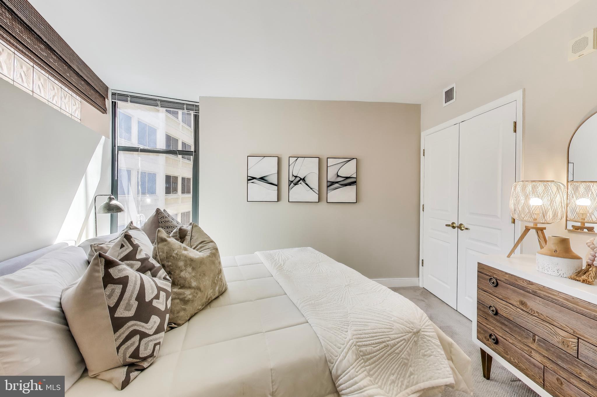 616 E Street Northwest, Unit 648 Washington, DC 20004 - Photo 15 of 39 a bedroom with a large bed and a mirror