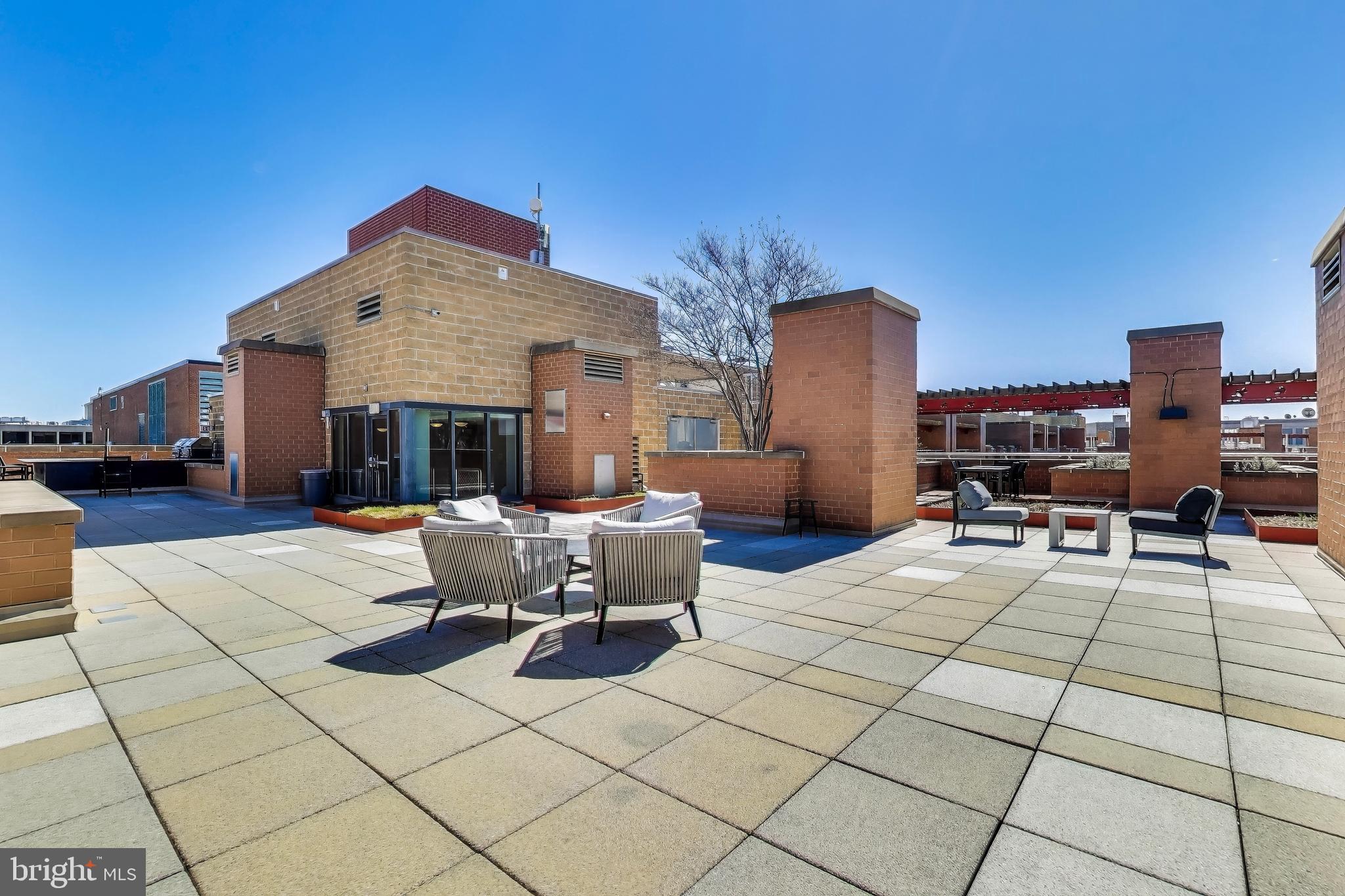 616 E Street Northwest, Unit 648 Washington, DC 20004 - Photo 23 of 39 a view of a patio with dining table and chairs with a barbeque grill and plants