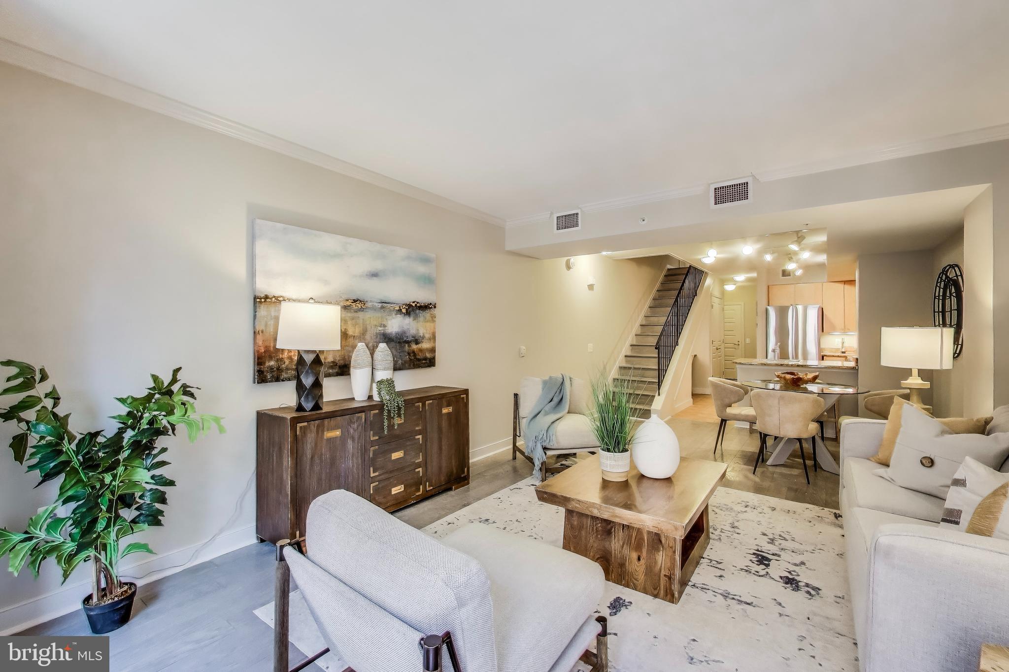 616 E Street Northwest, Unit 648 Washington, DC 20004 - Photo 5 of 39 a living room with furniture and a large mirror with potted plants