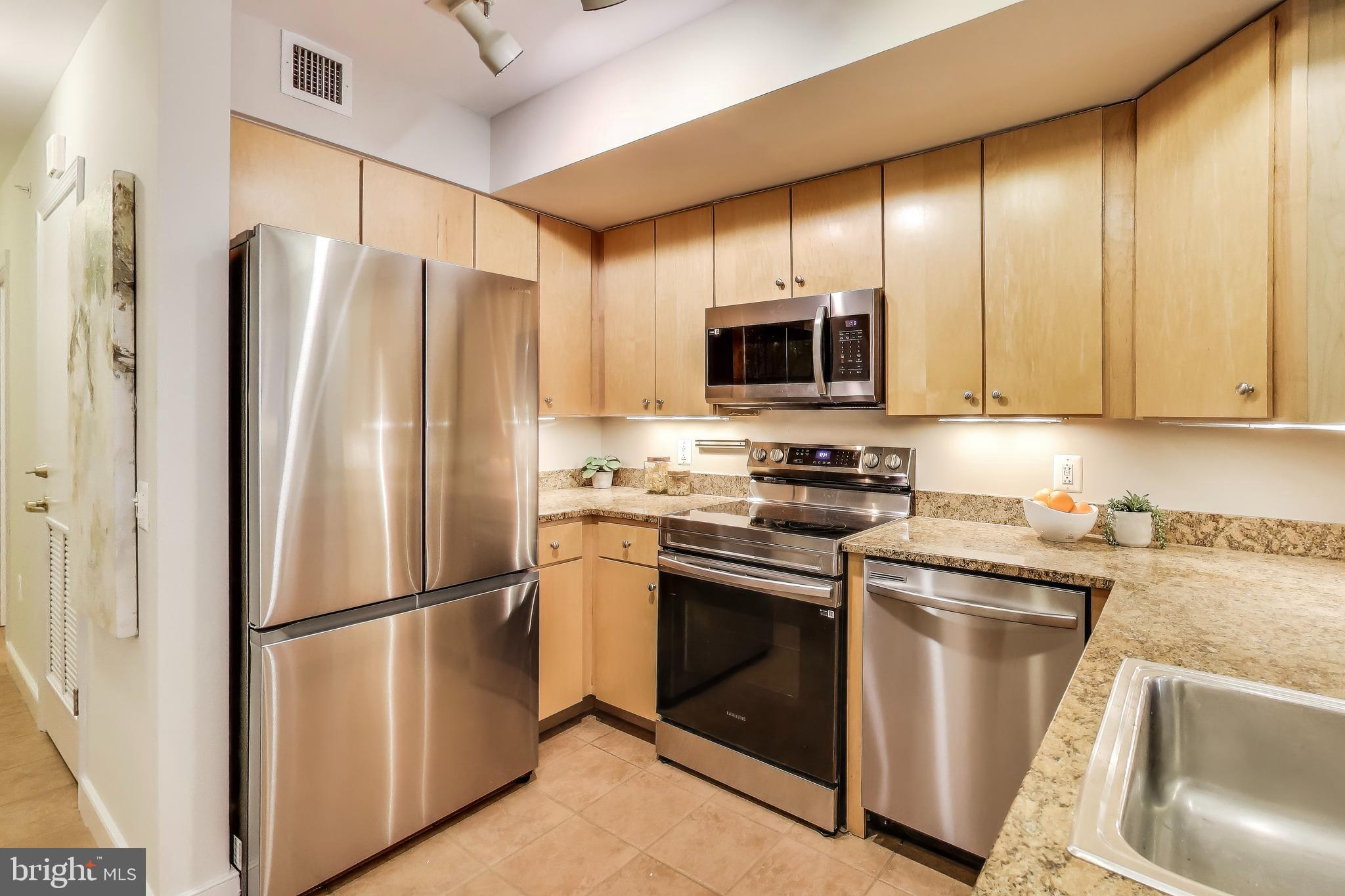 616 E Street Northwest, Unit 648 Washington, DC 20004 - Photo 8 of 39 a kitchen with stainless steel appliances granite countertop a refrigerator stove and microwave