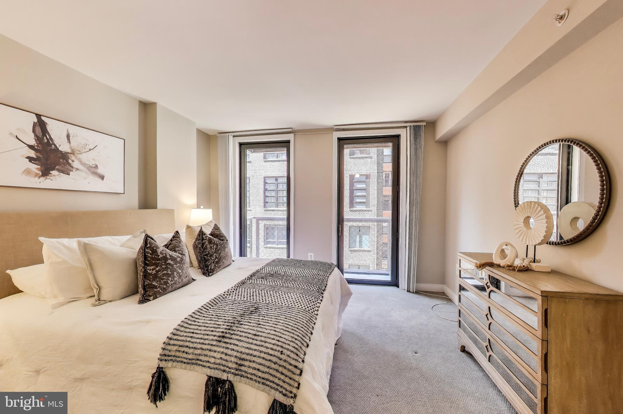 616 E Street Northwest, Unit 648 Washington, DC 20004 - Photo 10 of 39 a bedroom with a bed a mirror and a window