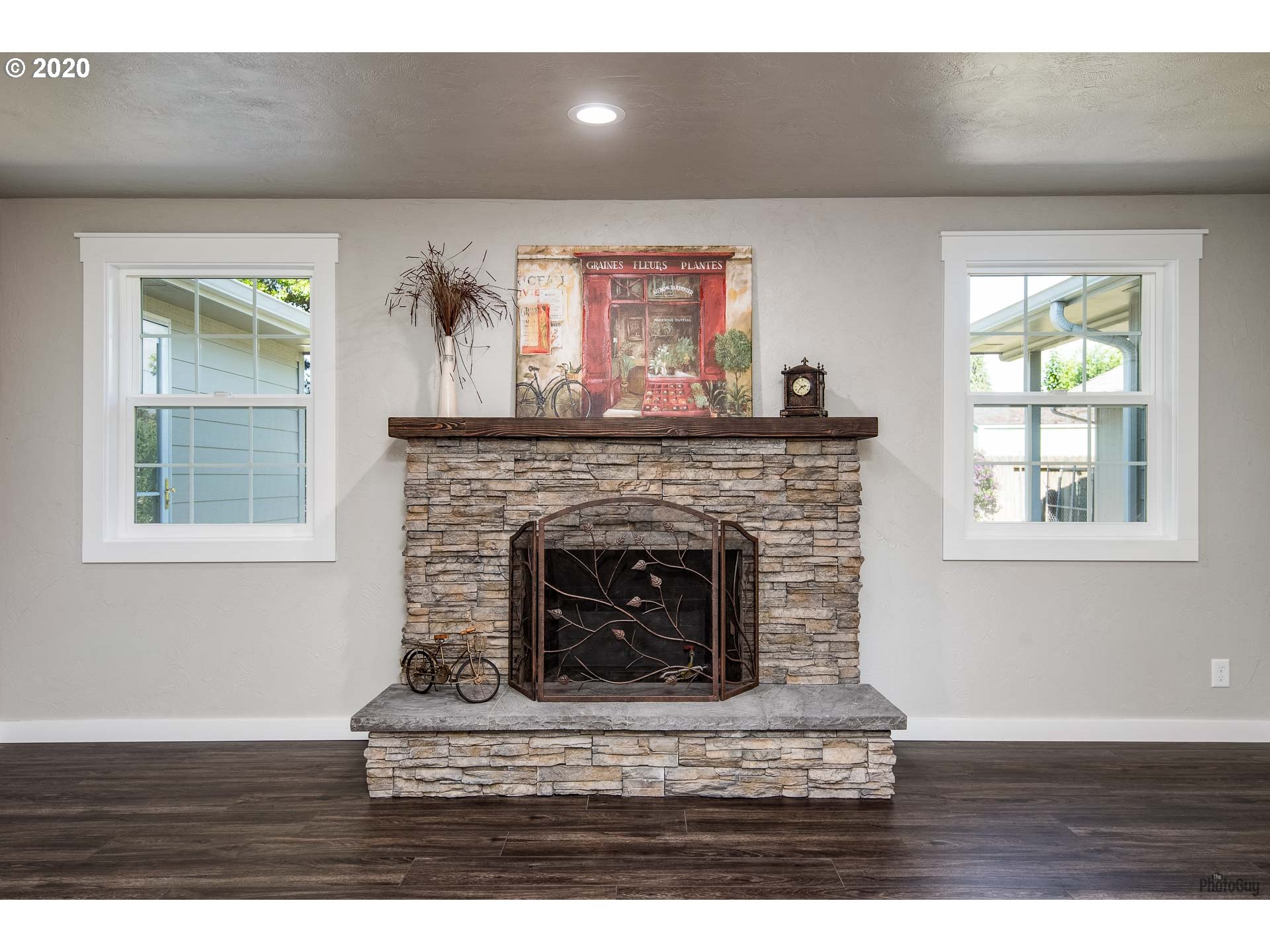 2470 North 14th Place Springfield, OR 97477 - Photo 4 of 32 a living room with a fireplace and a wooden floor