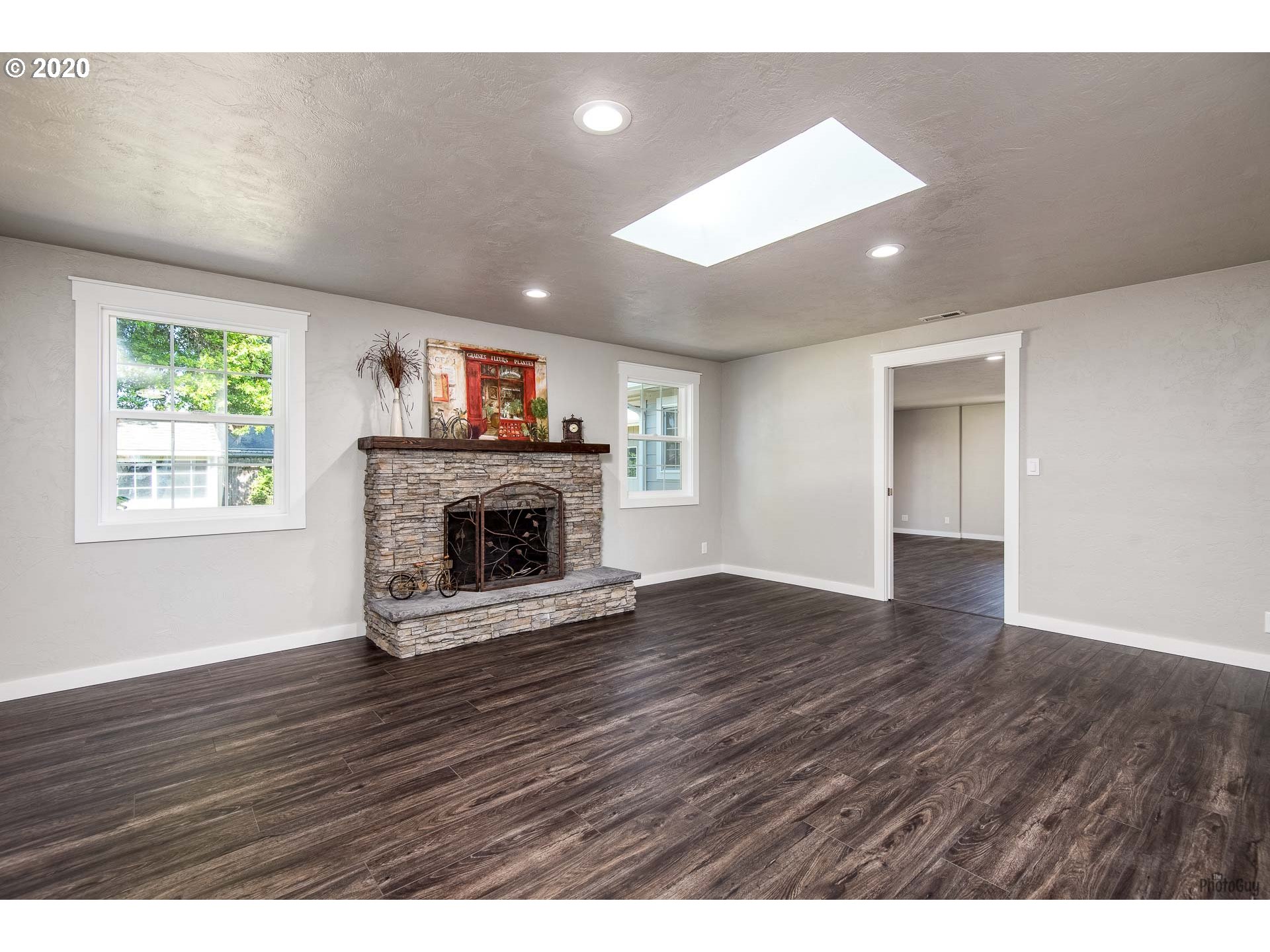 2470 North 14th Place Springfield, OR 97477 - Photo 5 of 32 an empty room with wooden floor a fireplace and windows