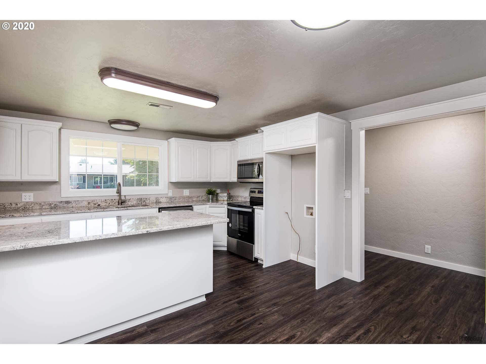 2470 North 14th Place Springfield, OR 97477 - Photo 10 of 32 a kitchen with stainless steel appliances granite countertop a sink cabinets and wooden floor