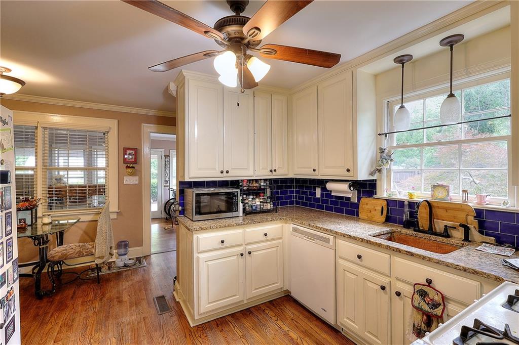 317 North Cherokee Road Social Circle, GA 30025 - Photo 9 of 32 a kitchen with stainless steel appliances sink cabinets and wooden floor