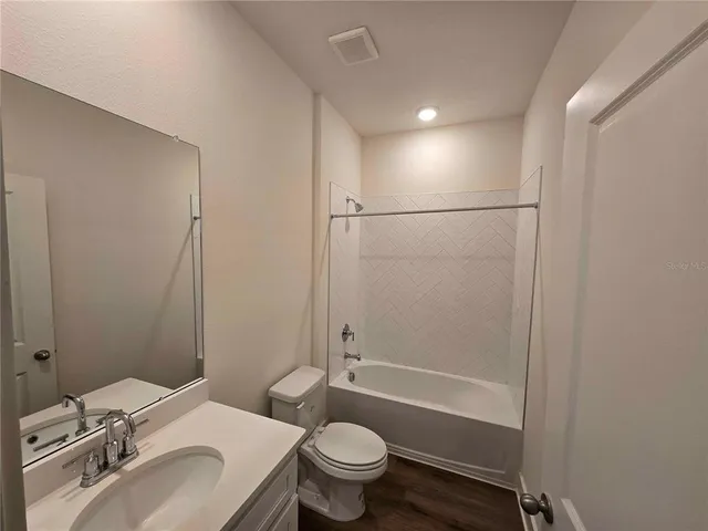 a bathroom with a sink toilet vanity and shower