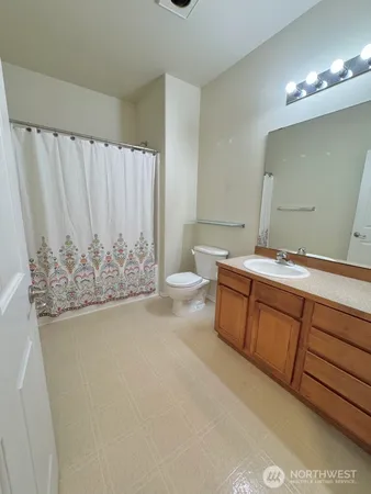 a bathroom with a granite countertop sink a toilet and a mirror