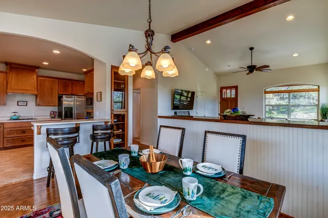 a kitchen with stainless steel appliances granite countertop a stove a kitchen island a dining table and chairs with wooden floor