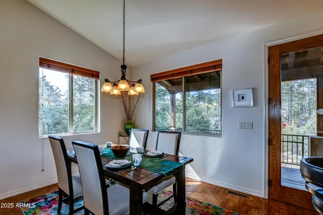 a dining room with furniture a chandelier and wooden floor