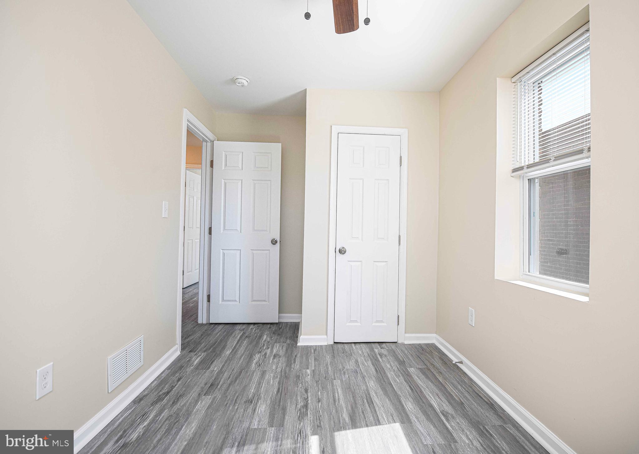 5332 Cuthbert Avenue Baltimore, MD 21215 - Photo 14 of 33 an empty room with wooden floor and windows