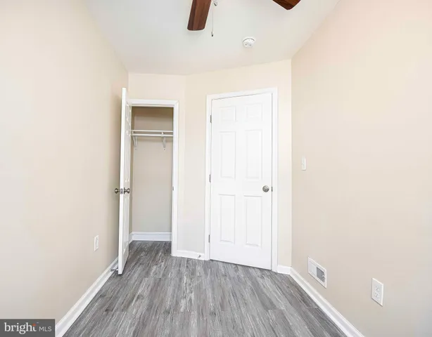 a view of an empty room with closet and a window