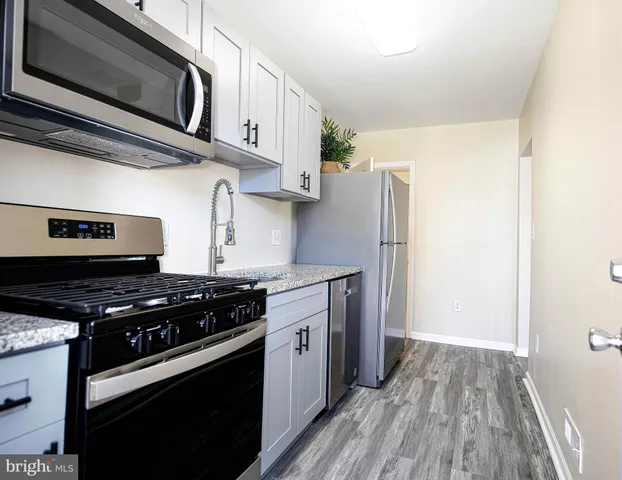 a kitchen with stainless steel appliances a stove a microwave and a refrigerator