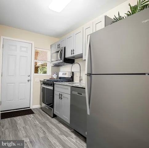 a kitchen with stainless steel appliances a refrigerator sink and microwave