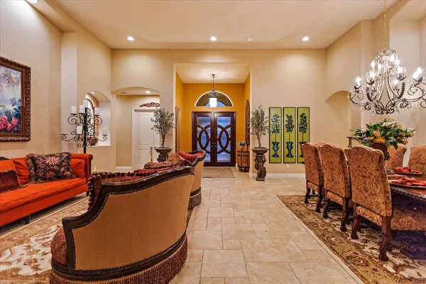 a living room with furniture a chandelier and a rug