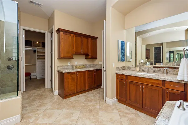 a bathroom with a granite countertop sink toilet mirror and shower