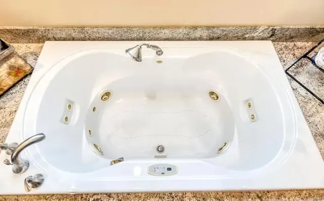 a spacious bedroom with a bed and a chandelier