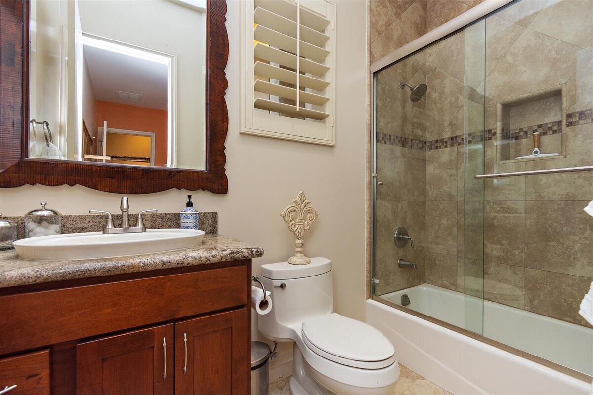31453 Chimayo Road Thousand Palms, CA 92276 - Photo 32 of 71 a bathroom with a granite countertop sink toilet mirror and shower