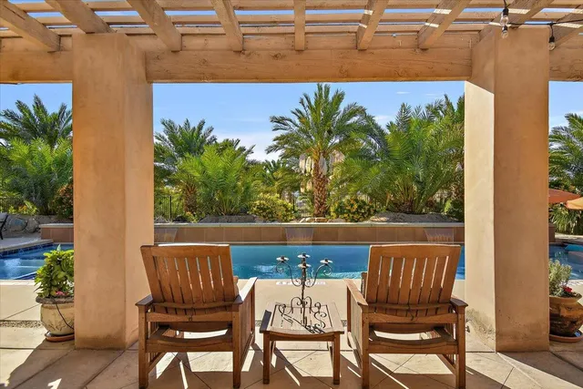 a view of a patio with table and chairs with wooden floor and fence