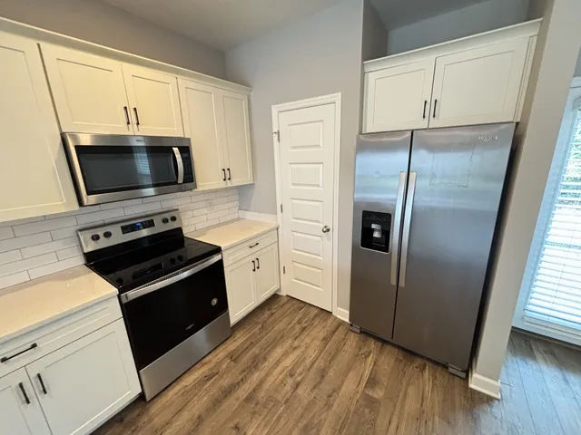 a kitchen with a sink cabinets and wooden floor
