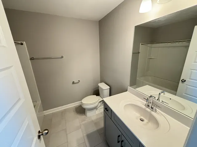 an empty room with windows and ceiling fan