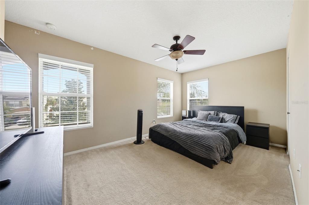 1765 Strathmore Circle Mount Dora, FL 32757 - Photo 19 of 51 a spacious bedroom with a large bed and a chandelier