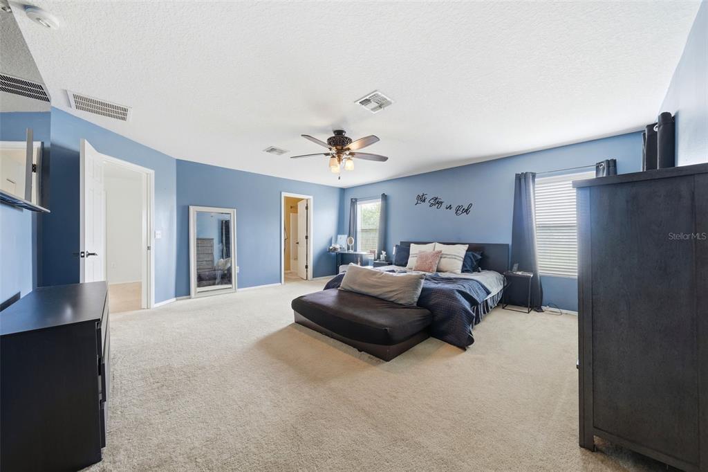 1765 Strathmore Circle Mount Dora, FL 32757 - Photo 25 of 51 a bedroom with a large bed and a chandelier