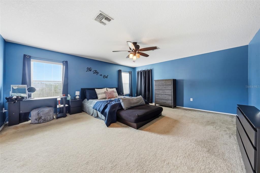 1765 Strathmore Circle Mount Dora, FL 32757 - Photo 27 of 51 a bedroom with a large bed and a chandelier