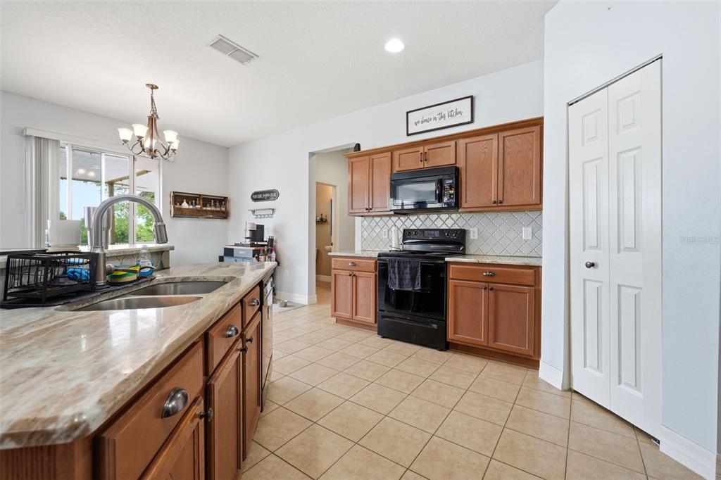 1765 Strathmore Circle Mount Dora, FL 32757 - Photo 35 of 51 a kitchen with stainless steel appliances a sink counter space cabinets and a refrigerator