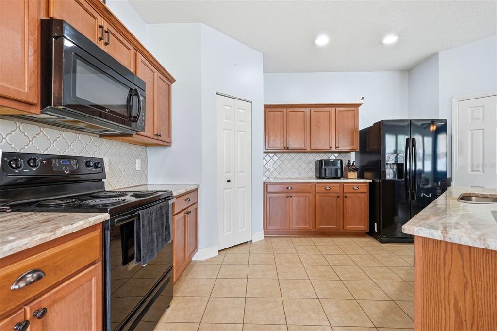 1765 Strathmore Circle Mount Dora, FL 32757 - Photo 36 of 51 a kitchen with stainless steel appliances granite countertop a stove a refrigerator and a microwave