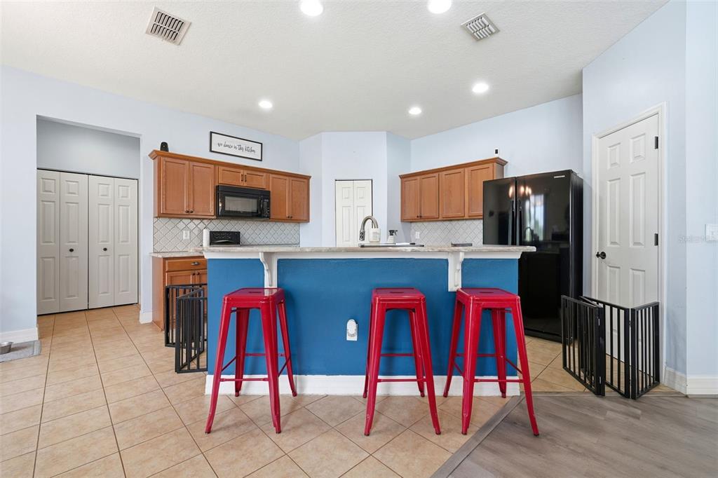 1765 Strathmore Circle Mount Dora, FL 32757 - Photo 37 of 51 a kitchen with stainless steel appliances kitchen island granite countertop a refrigerator and microwave