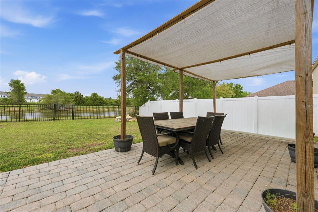 1765 Strathmore Circle Mount Dora, FL 32757 - Photo 38 of 51 a view of a patio with a table chairs and a yard