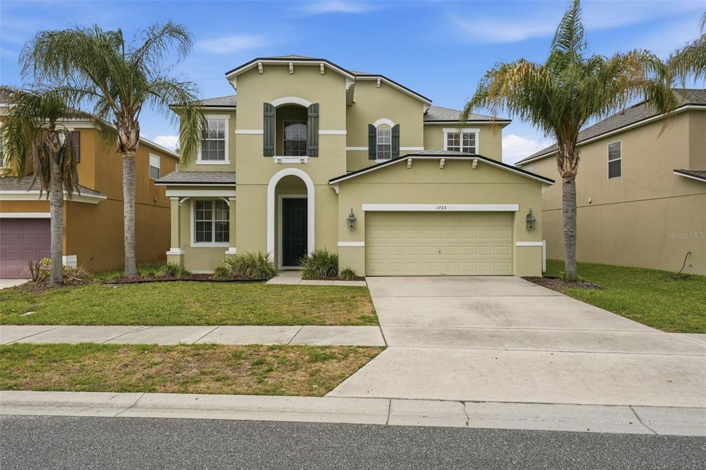 1765 Strathmore Circle Mount Dora, FL 32757 - Photo 4 of 51 a front view of a house with a yard and garage